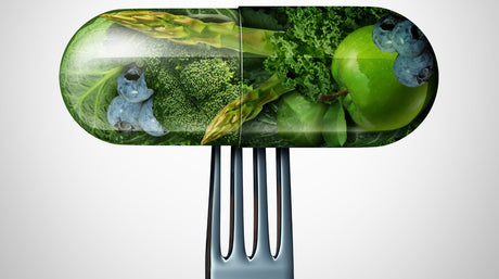 A pill or medicine capsule with fresh fruit and vegetables inside on a fork to help illustrate best vitamins for bariatric patients