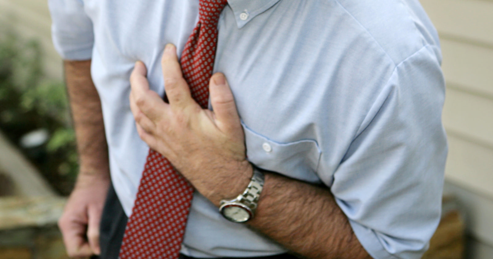 A mature businessman doubled over clutching his chest to help illustrate Does Weight loss Surgery Lead to a Reduction in Cardiovascular Risk Factors