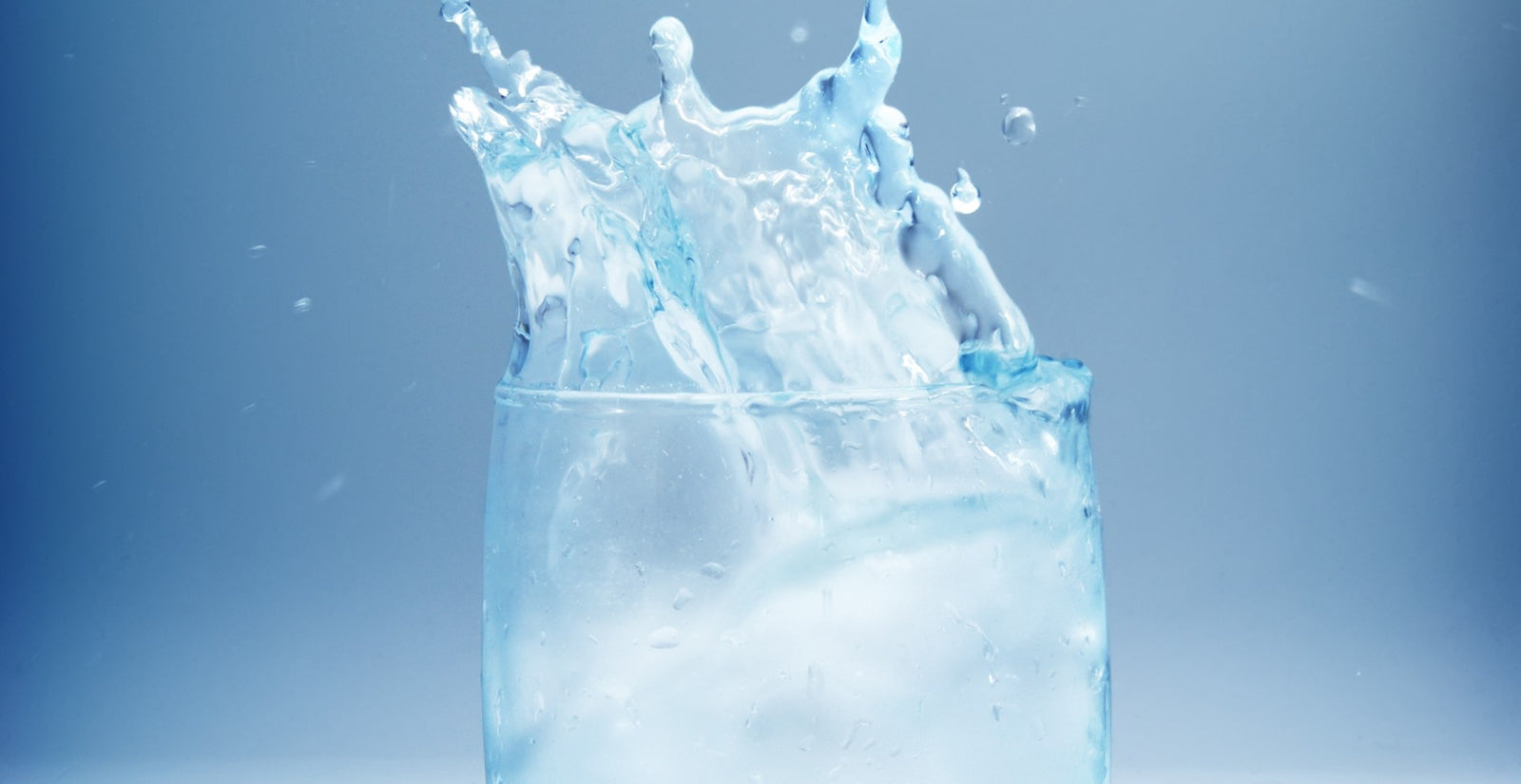 Water splashing out of a glass to illustrate too much water after gastric sleeve and Hydration and Fluid Intake After Bariatric Surgery
